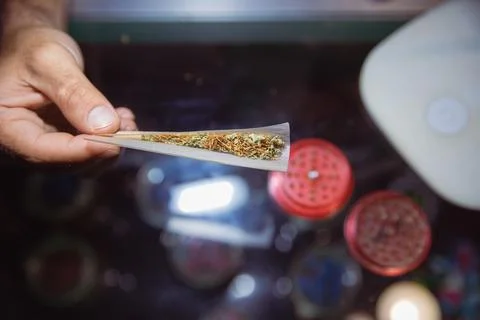Close up of a joint of marijuana opened while rolling. Grinder open in the .. Stock Photos