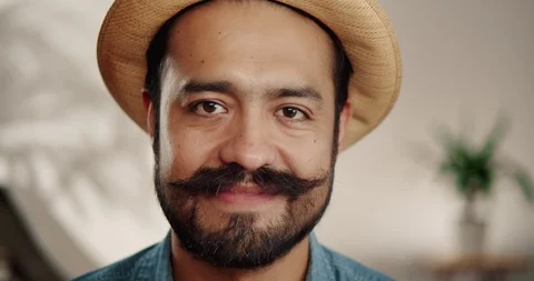 Close up of joyful guy wide smiling and fixing cute mustache with both hands Video stock 120744247