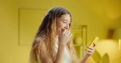 Close up of joyful young woman using a mobile phone and reading funny chat Stock Footage 188097065