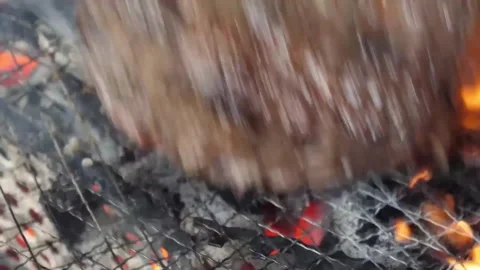 Close-up of juicy beef steak grilling on an iron barbecue grate with roaring fla Stock Footage 338211690