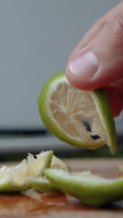 Close-up of a juicy lime being cut with a knife. The process of preparing a Stock Footage 279914963