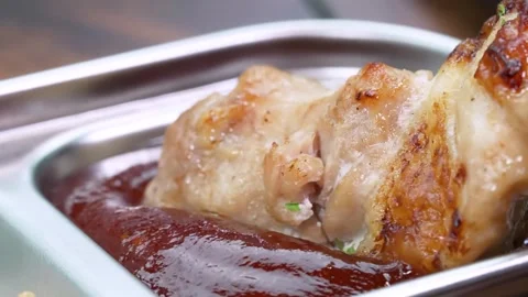 Close-up of Juicy Roasted Pork Knuckle Dipped in Rich Brown Gravy Sauce Stock Footage 337440802