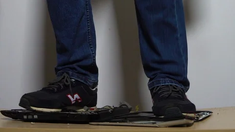 Close-up, a jumping man in slow motion breaks the laptop. 120 frames. Stock Footage 120016046