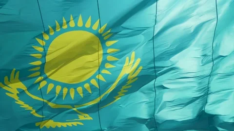 Close up of Kazakh flag flying on wind. Waving flag on flagpole against blue sky Stock Footage 242555583