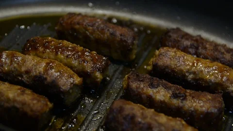 Close up of Kebab frying on a pan with sizzling oil and fat. low light. Vídeos de archivo 108737331