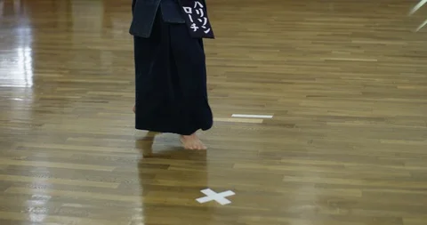 Close up of kendo practitioner's feet stepping backwards on wooden floor Stock Footage 124695201