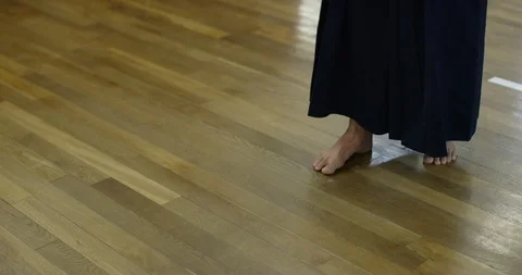 Close up of kendo practitioner's feet stepping backwards on wooden floor Stock Footage 124703178