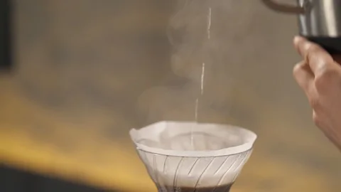 A close-up of a kettle and a spout with hot water poured into filter  Stock Footage 102306359