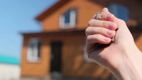 Close-up of a key with a house-shaped keychain in hand. Stock Footage 159008447