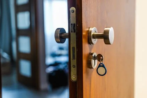 Close-Up of Key Inserted in Lock on Open Wooden Door Stock Photos