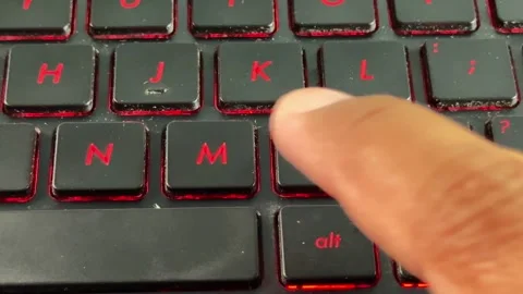 Close-up of keyboard typing with red backlight on "M" button, suitable for Stock Footage 335977378