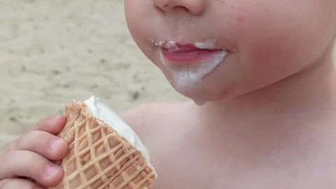 Close-up kid boy eats ice-cream, tasty ice cream in waffle,summer time joy. Stock Footage 246439312