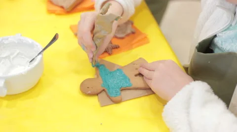 Close up of kid decorating the gingerbread cookies Vidéo 58381484
