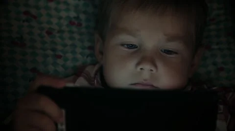 Close-up of kid face looking at tablet computer at night Stock Footage 67756970