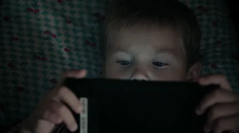 Close-up of kid face looking at tablet computer at night Stock Footage 67757022