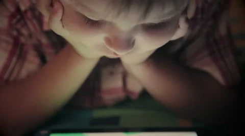 Close-up of kid face looking at tablet computer at night Stock Footage 67757057