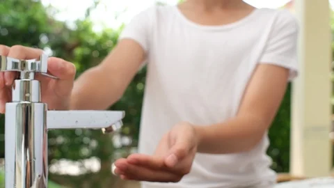 Close up at kid hand get water from modern faucet Stock Footage 125989207