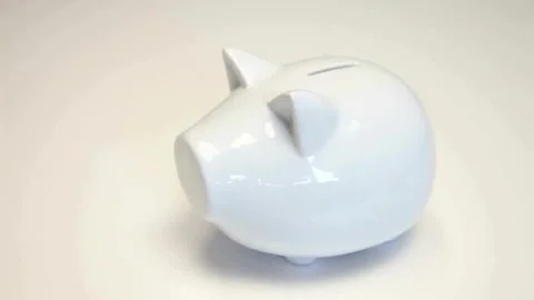 Close-up of kid hand putting coin into a piggy bank The boy puts the coins in Stock Footage 265936624