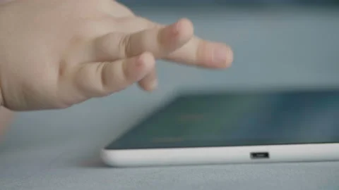 Close up of kid hand touching screen of touch pad. Funny games app. 库存影片 131944321