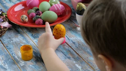 Close up of kid hands coloring easter eggs with egg dye. View from above Stock Footage 122906741