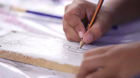 Close up on a kid hands drawing a car on wood with a pencil Stock Footage 239446294