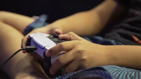 Close up of a kid hands playing in a ps5 controller. Stock Footage 231658186