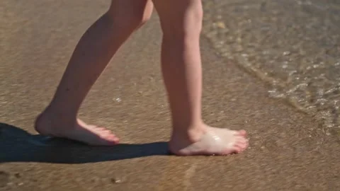 Close up kid legs on sand beach ocean shore at sunset. Summer vacation, holiday Stock Footage 275880684