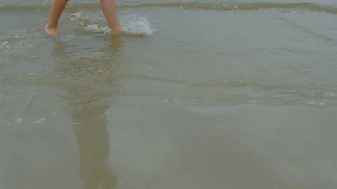 Close up of kid legs walking on the beach in a cloudy morning. Stock Footage 137773113
