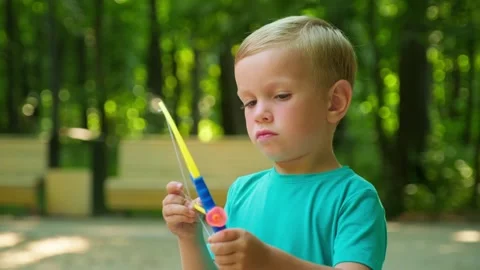 Close up of a kid shooting an arrow from a toy bow on a playground outdoors.. Stock-Footage 339551122
