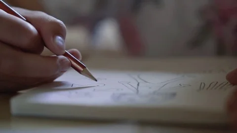 Close up of kid's hand drawing a fish picture on white paper with pencil Stock Footage 80637008