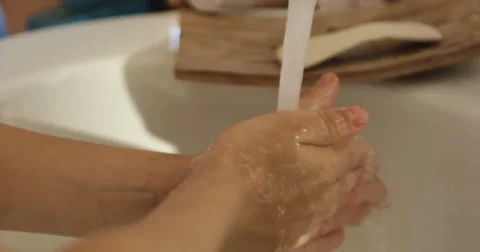 Close-up of kid's hand under stream of water in bathroom in slow motion Stock Footage 66063844
