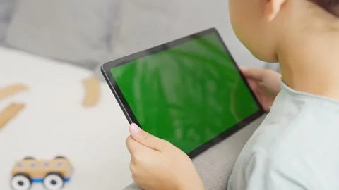 Close up kids hands holding, tapping on a tablet with green screen. Mock up Stock-Footage 255511135