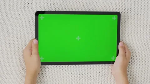 Close up kids hands holding, tapping on a tablet with green screen. Mock up Stock Footage 257647433