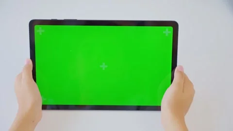 Close up kids hands holding, tapping on a tablet with green screen. Mock up Stock Footage 258366105