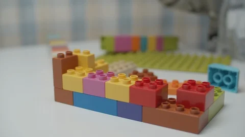 Close up of kids hands playing with constructor on the white table. Building Vídeos de archivo 118822504