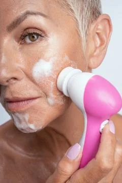 Close up of kind blond that doing face massage Фото