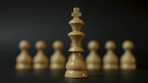 Close up of king chess piece standing in front of pawns on black background Stock Footage 287880625