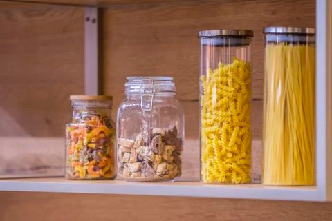 Close up of the kitchen objects - cookie jar, jars with pasta. Stock Photos