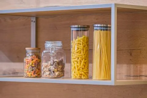 Close up of the kitchen objects - cookie jar, jars with pasta. Stock Photos