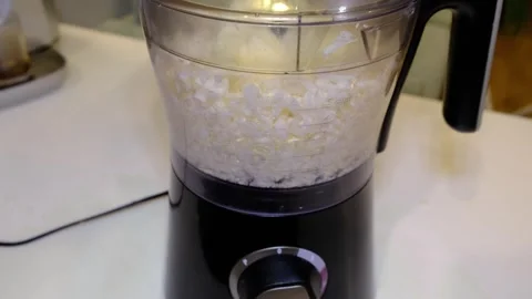 Close kitchen shot of a food processor shredding cabbage into fine strands Stock Footage 329922479