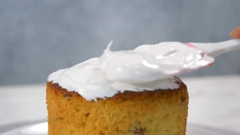 Close-up. A kitchen spatula smears icing on delicious Orthodox Easter bread, a Stock Footage 169414990