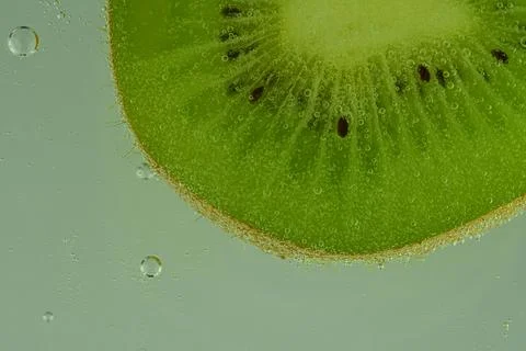 Close-up of kiwi fruit in liquid with bubbles. Slice of green ripe kiwi fru.. Stock Photos