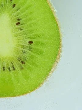 Close-up of kiwi fruit in liquid with bubbles. Slice of green ripe kiwi fru.. Fotos de archivo