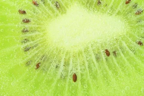 Close-up of kiwi fruit in liquid with bubbles. Slice of green ripe kiwi fru.. Fotos de archivo