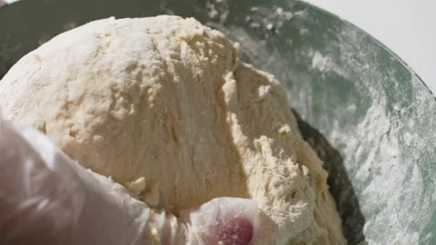 Close-up kneading of soft dough in a green bowl, dusted with flour. Stock Footage 322746952