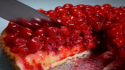 Close-up of a knife cutting a piece of a Fresh raspberry jelly-covered pie Stock Footage 195700603