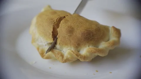 Close up of a knife cutting a recently baked warm empanada. Argentina Stock Footage 148053307
