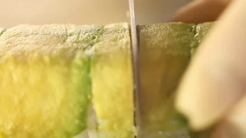 Close-up of knife cutting sushi roll of rice and smoked eel with a knife. Stock Footage 120816104