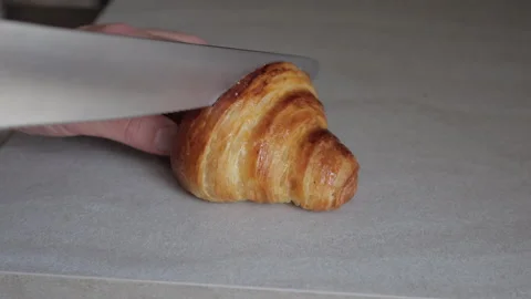 Close-Up of Knife Cutting Through Buttery Croissant Stock Footage 306757628