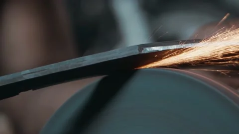 Close up of a knife sharpened on rotating machine, hot sparks flying slow motion Stock Footage 142789841